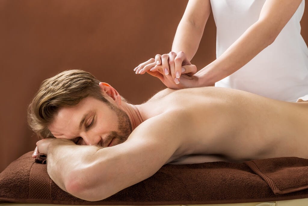 Wooden massage tools and stones on slate for deep tissue therapy